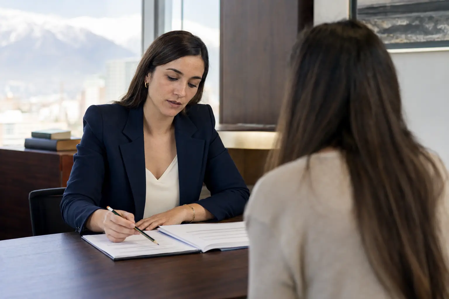 Abogada de familia revisando con una persona los antecedentes para solicitar una orden de alejamiento